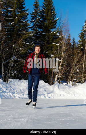 Lächelnder junge Mann Eislaufen Stockfoto