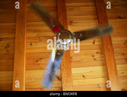 Silber Deckenventilator auf einem goldenen Holzbalken Hintergrund, Sommer-Metapher Stockfoto