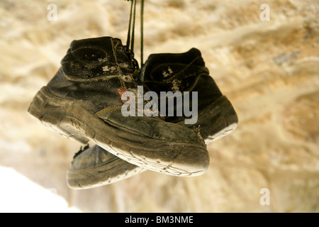 Bauarbeiter verließ seine Alter alte Stiefel entfernt, Hunged auf den Felsen Stockfoto