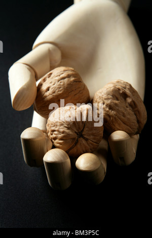 Puppe aus Holz Hand mit drei Walnüsse in offene hand Stockfoto