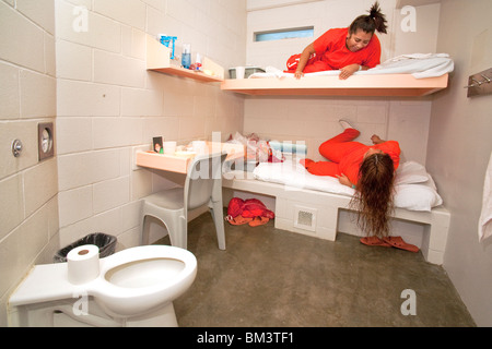 Hispanische Häftlinge teilen sich eine zwei-Personen-Zelle in die weibliche Einheit von Santa Ana, Kalifornien, Stadtgefängnis. Beachten Sie orange Gefängnis Uniformen. Stockfoto