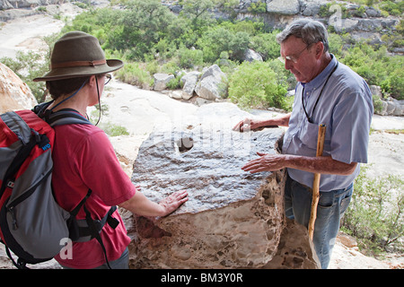 Guide zeigt Kratzspuren auf Felsen Besucher am Schicksal Bell Tierheim Seminole Canyon Rock Art Texas USA Stockfoto