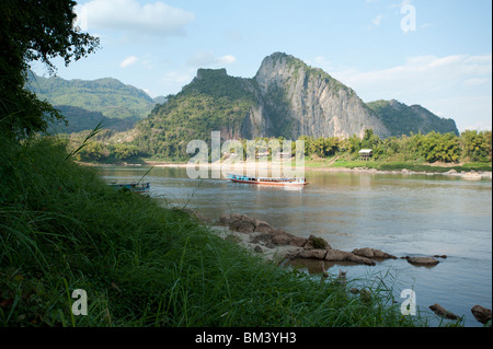 Ein Passagierboot fährt an den Karstbergen in der Nähe der vorbei Peak Ou Höhlen am Mekong Fluss bei Luang Prabang Laos Stockfoto