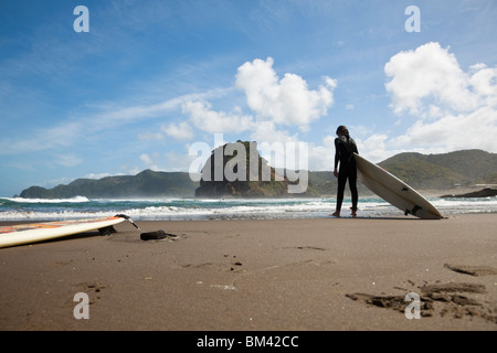 Surfer am Strand Piha. Piha, Waitakere Ranges Regional Park, Auckland, Nordinsel, Neuseeland Stockfoto