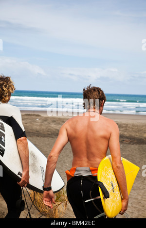 Surfer Fuß hinunter zum Strand Piha. Piha, Waitakere Ranges Regional Park, Auckland, Nordinsel, Neuseeland Stockfoto