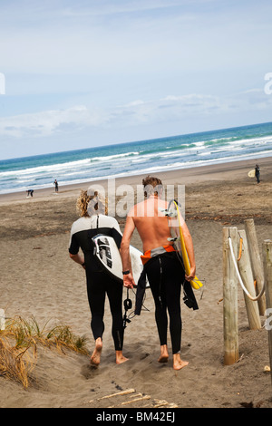 Surfer Fuß hinunter zum Strand Piha. Piha, Waitakere Ranges Regional Park, Auckland, Nordinsel, Neuseeland Stockfoto