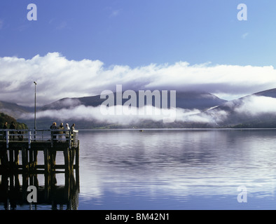 Inveraray, Argyll und Bute, Scotland, UK, Menschen auf dem Pier im Loch Fyne auf beruhigen Herbstmorgen mit niedrigen Wolken über dem Wasser Stockfoto