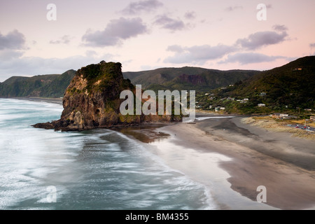Piha Beach und Lion Rock bei Sonnenuntergang. Piha, Waitakere Ranges Regional Park, Auckland, Nordinsel, Neuseeland Stockfoto