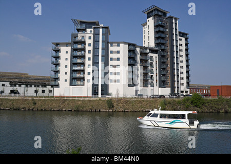 Cardiff Bay Aquabus vorbei an einem modernen Wohnblock am Fluss Taff Cardiff Wales Großbritannien britische Stadtbebauungen moderner Apartmentblock Stockfoto