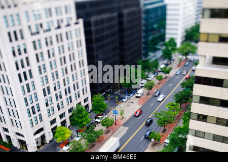 K Street Downtown Tilt-Shift Washington DC | WASHINGTON D.C., Vereinigte Staaten – ein weiterer Blick auf die K Street in der 19th Street NW stellt den Verkehr und die Bürotürme in der Innenstadt als Miniatur-Diorama dar. Die optische Illusion entsteht aus einem künstlich schmalen Fokusband, das Makrofotografie nachahmt, eine Technik, die häufig verwendet wird, um gewöhnlichen Stadtansichten ein verspieltes, modellähnliches Aussehen zu verleihen. Die K Street ist das zentrale Geschäftsviertel von Washington. Stockfoto