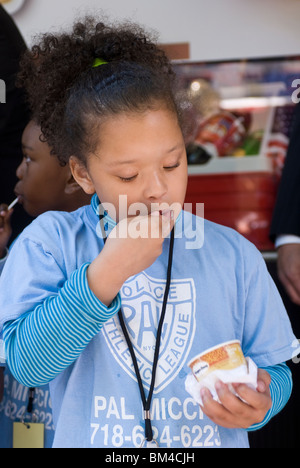 Kinder aus der Police Athletic League Essen Häagen-Dazs Eis in New York Stockfoto