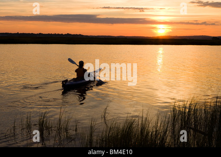 Eine Frau Kajaks bei Sonnenuntergang in den Connecticut River in Old Lyme, Connecticut. Stockfoto