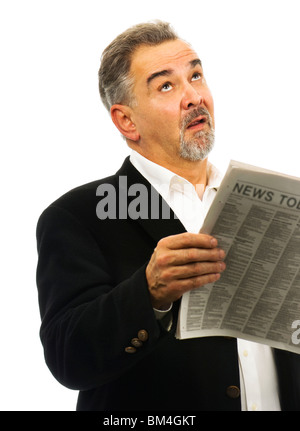 Reifer Mann sieht seine Zeitung mit gedrückter himmelwärts mit einem Blick der Verzweiflung. Stockfoto