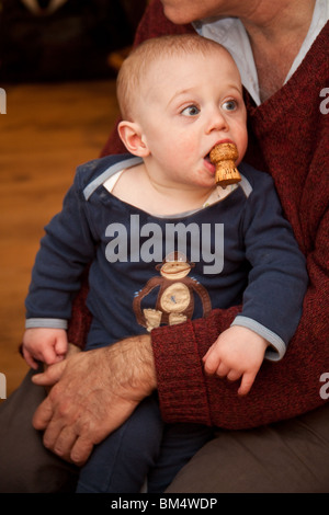 Jungen 11 Monate alt mit einem Champagner Korken in den Mund. Stockfoto