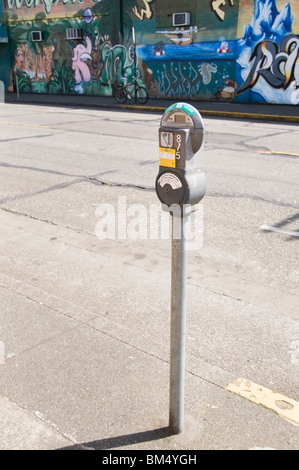 Parkuhr in der Innenstadt von Olympia, Washington mit Graffiti Wandbild an der Wand im Hintergrund. Stockfoto