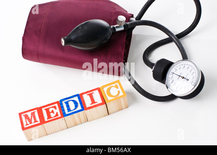 Bunte Kinder-Blöcke Rechtschreibung MEDIC mit einer Blutdruckmanschette Stockfoto