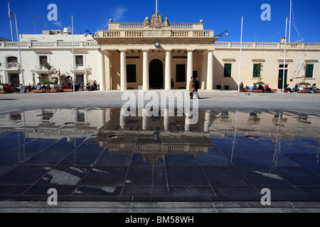 Vorbei an ein paar einen Brunnen in einem Quadrat. Dahinter befindet sich ein sechs Säulen-Portikus. Es gibt Spiegelungen im Wasser. Stockfoto