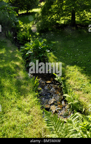Eine schnell bewegte Rill (oder Strom) in einem englischen Landhaus-Garten. Stockfoto