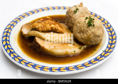 Schweinebraten (Schweinesbraten) serviert mit knusprigen Knistern und Knödel in Bayern, Deutschland. Stockfoto