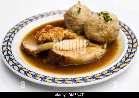 Schweinebraten (Schweinesbraten) serviert mit knusprigen Knistern und Knödel in Bayern, Deutschland. Stockfoto