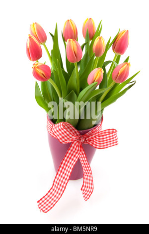 Fröhliche Vase mit Strauß Tulpen und Zierband Stockfoto