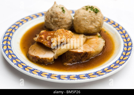 Schweinebraten (Schweinesbraten) serviert mit knusprigen Knistern und Knödel in Bayern, Deutschland. Stockfoto