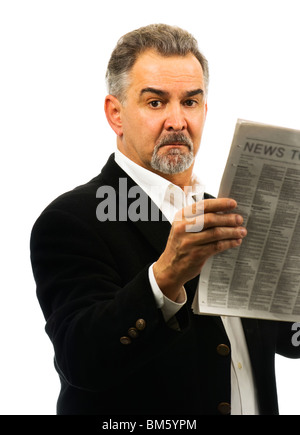 Ein reifer Mann, schaut direkt in die Kamera, ernst und halten eine Zeitung. Stockfoto