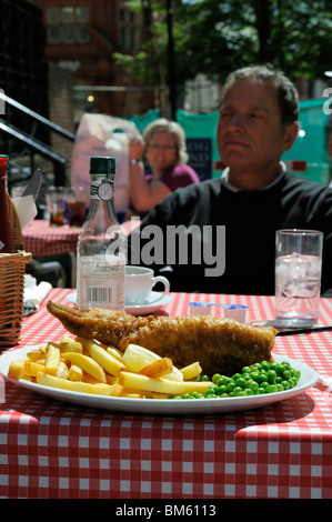 Ein Mann und Fish and Chips auf einer Terrasse des Restaurants, london, großbritannien Stockfoto