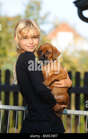 Rhodesian Ridgeback (Canis Lupus Familiaris). Junges Mädchen ein Welpe in ihren Armen hält. Stockfoto