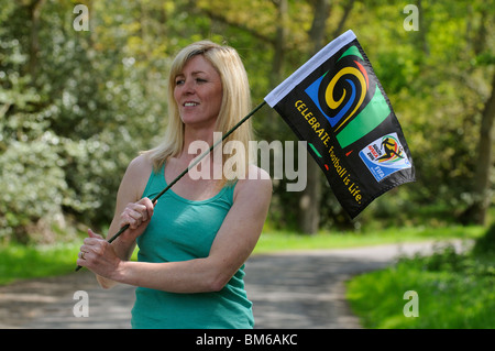 Weibliche südafrikanische Fußball-Anhänger umklammert ein Fußball ist Leben Weltmeisterschaft FIFA-Flag feiert die Meisterschaften 2010 Stockfoto