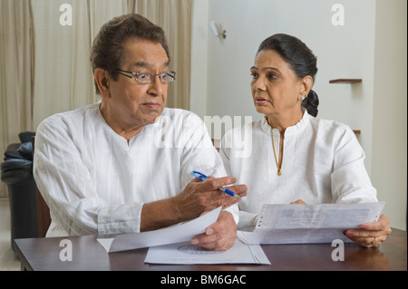 Mann sucht eine Rechnung, die im Besitz einer Frau überrascht Stockfoto
