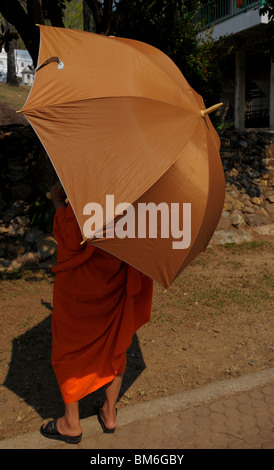 Mönch hält Regenschirm für den Schatten von Mittagssonne, Kam Ko Tempel Wat, Mae Hong Son, thailand Stockfoto