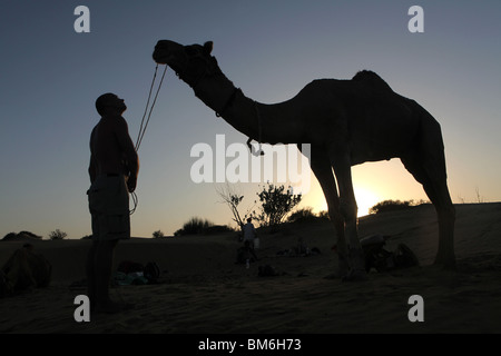 Ein Tourist mit seinem Kamel auf einem Kamel-Safari in den großen Thar Wüste außerhalb Jaisalmer, Rajasthan in Indien. Stockfoto