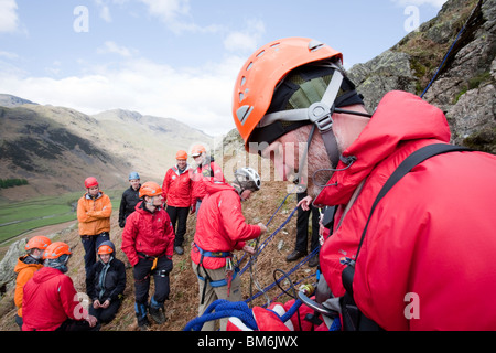 Mitglied des Berges Langdale/Ambleside Rettung bereitet sich auf eine Klippe auf einer Trainingsübung gesenkt werden Stockfoto