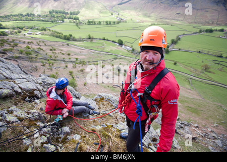 Mitglied der Bergrettung Langdale/Ambleside ist von einer Klippe auf einer Trainingsübung gesenkt. Stockfoto