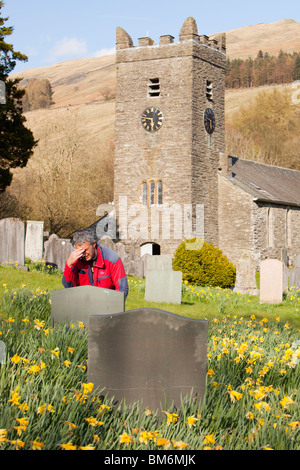 Ein Trauernder an eine ernste Seite in Troutbeck Kirche im Frühjahr, Lake District, Großbritannien. Stockfoto