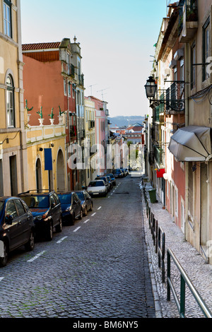 Eine engen kopfsteingepflasterten Seitenstraße mit Autos geparkt auf einer Seite und einen schmalen Gehweg auf der anderen. Stockfoto