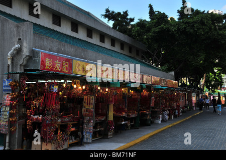 Schrägansicht von 10 Ständen, beleuchtet durch elektrisches Licht, Weihrauch am Eingang an der Wong Tai Sin Temple in Hong Kong zu verkaufen Stockfoto