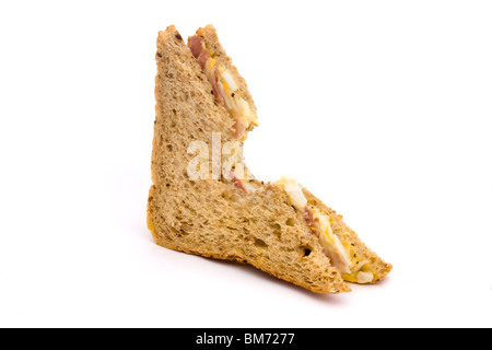 halb ein Ei und Speck Sandwich mit einem Biss genommen auf weißem Hintergrund Stockfoto