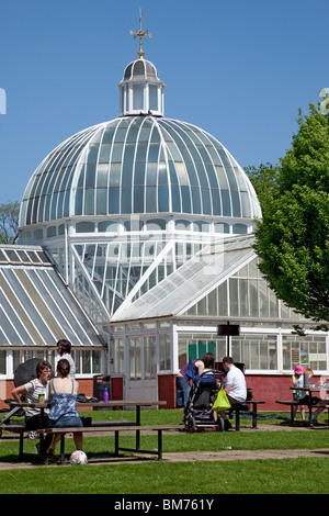 Menschen außerhalb das Gewächshaus an Queens Park auf der Südseite von Glasgow, Schottland an einem heißen, sonnigen Mai Tag entspannen. Stockfoto