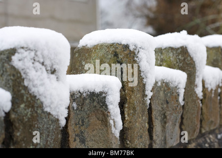 Ein Schnee Abdeckung Steinmauer an einem ungewöhnlich kalten Wintertag in Newton, Porthcawl, Mid Glamorgan Stockfoto