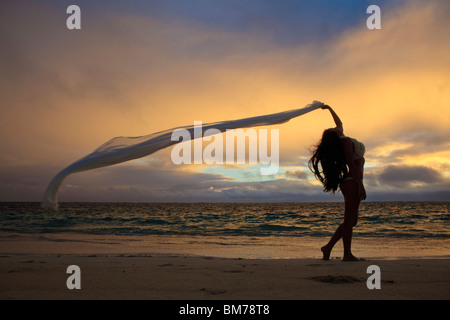 schöne junge Frau am Strand von Lanikai bei Sonnenaufgang Stockfoto