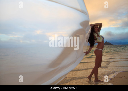 schöne junge Frau am Strand von Lanikai bei Sonnenaufgang Stockfoto