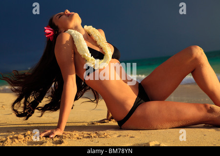 schöne junge Frau am Strand von Lanikai bei Sonnenaufgang Stockfoto