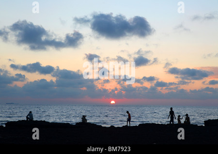 Sonnenuntergänge über die Felsen am Strand von Anjuna im nördlichen Goa, Bundesstaat Goa, Indien. Stockfoto