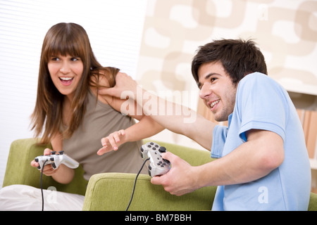 Student - pad glücklich Jugendliche Videospiel mit Kontrolle spielen im Wohnzimmer Stockfoto