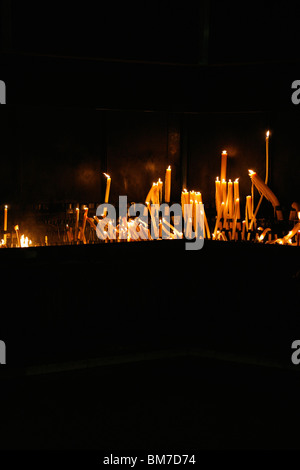 Brennende Kerzen auf einem Altar angeordnet Stockfoto