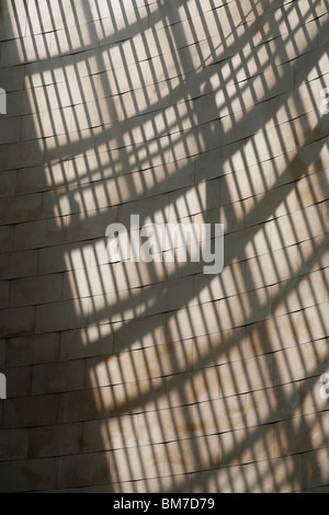 Sonnenlicht und Schatten von Balken auf einer Steinmauer Stockfoto