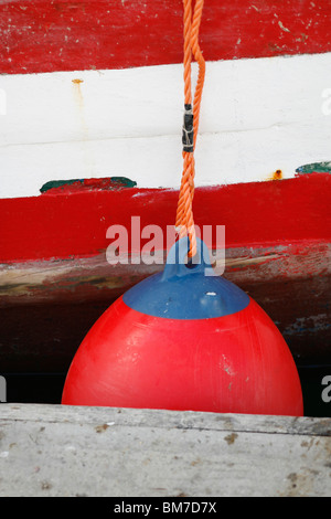 Eine Boot-Stoßstange gebunden an ein Boot an einem Steg Stockfoto