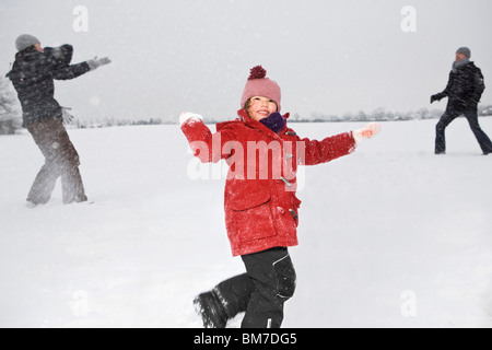 Zwei Eltern und ihre Töchter haben eine Schneeballschlacht Stockfoto